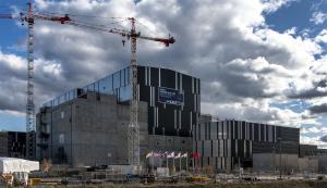 English: Photo of the exterior of the ITER collaboration Tokamak Complex, a modern mirrored building surrounded by cranes. Français: Photo du chantier ITER le soir. On voit un bâtiment moderne, avec un bardage en acier, et une grue. Les membres d'ITER sont de 7 pays.